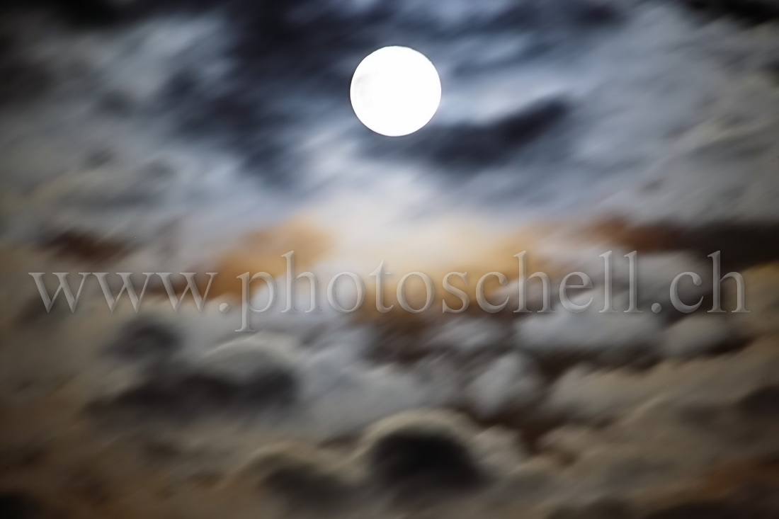 Reflets de la pleine lune dans les nuages
