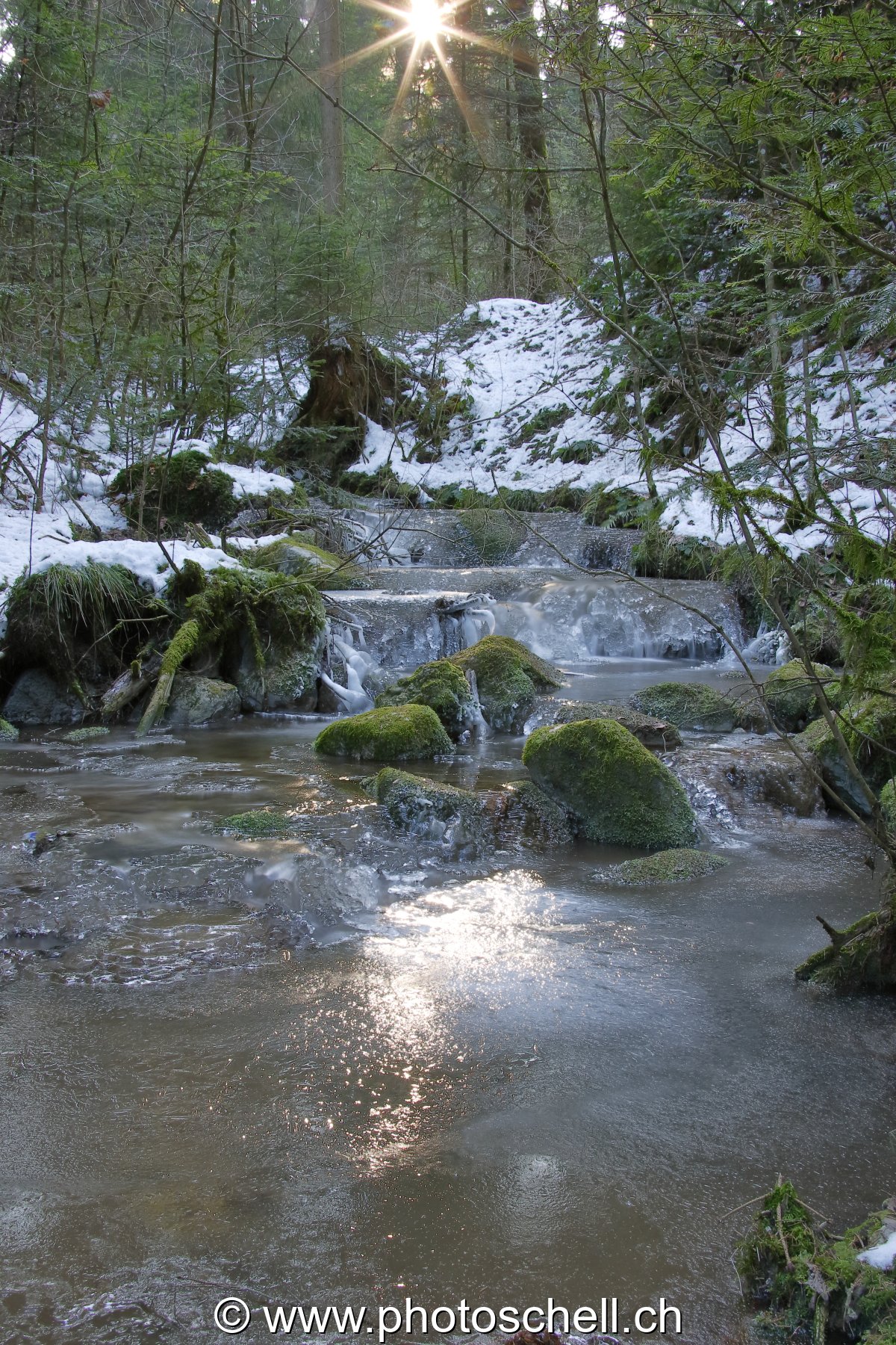 Soleil et son reflet dans le ruisseau glacé