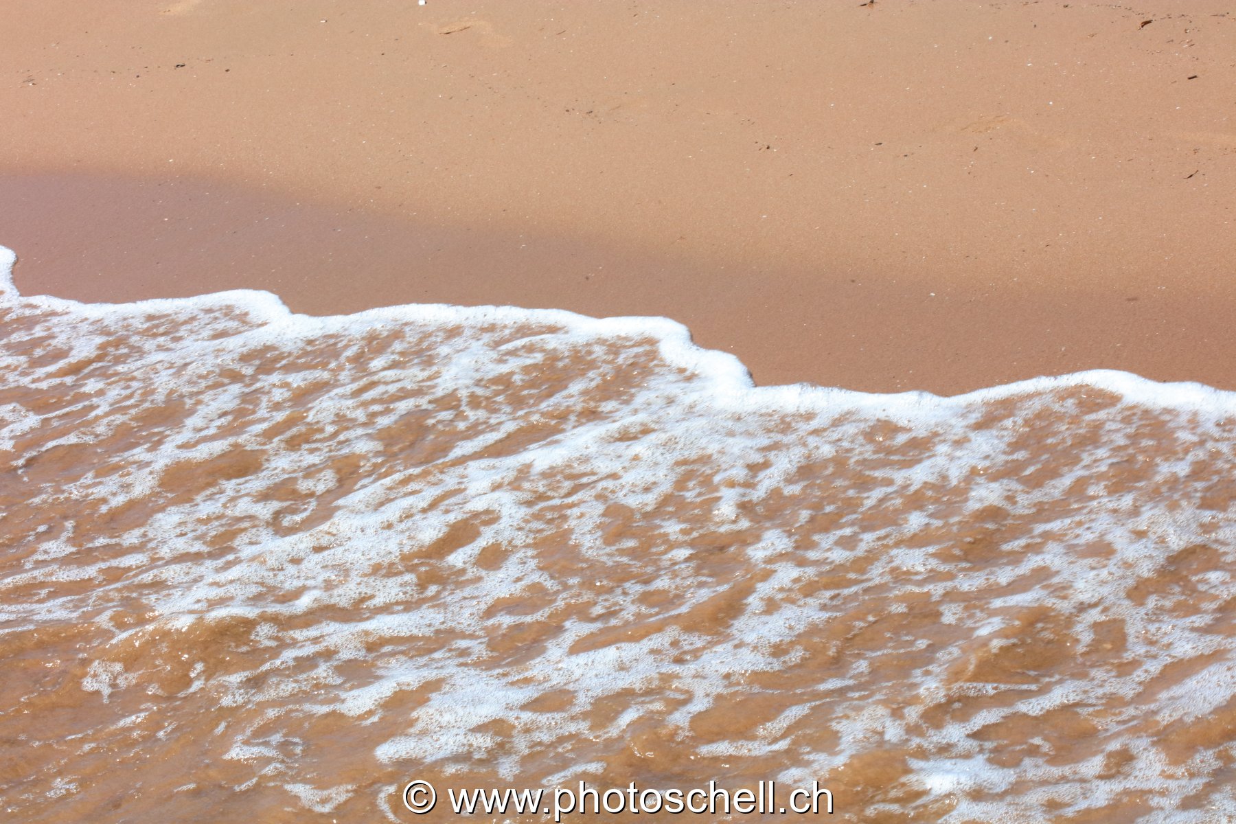 Vaguelettes s'écrasant sur la plage de sable