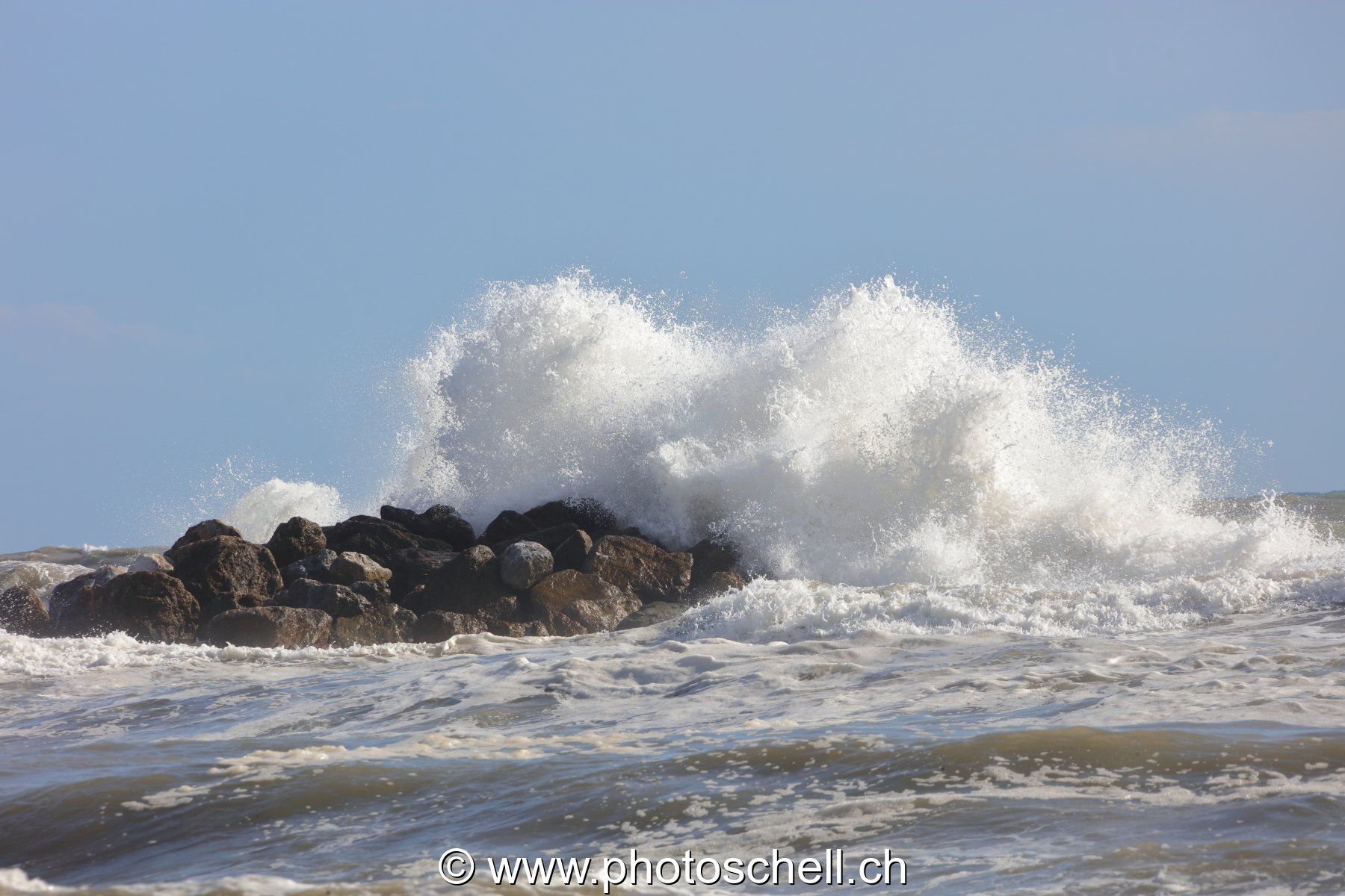 Vagues sécrasant sur un ilot rocheux
