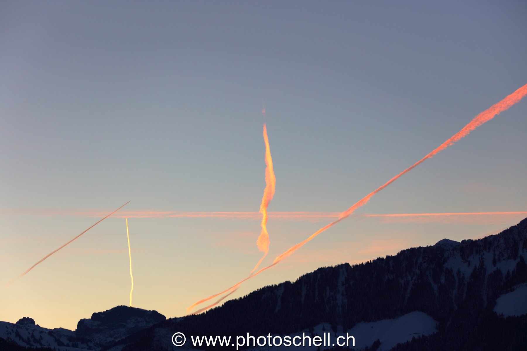 Trainées de condensation d'avions avant le lever de soleil