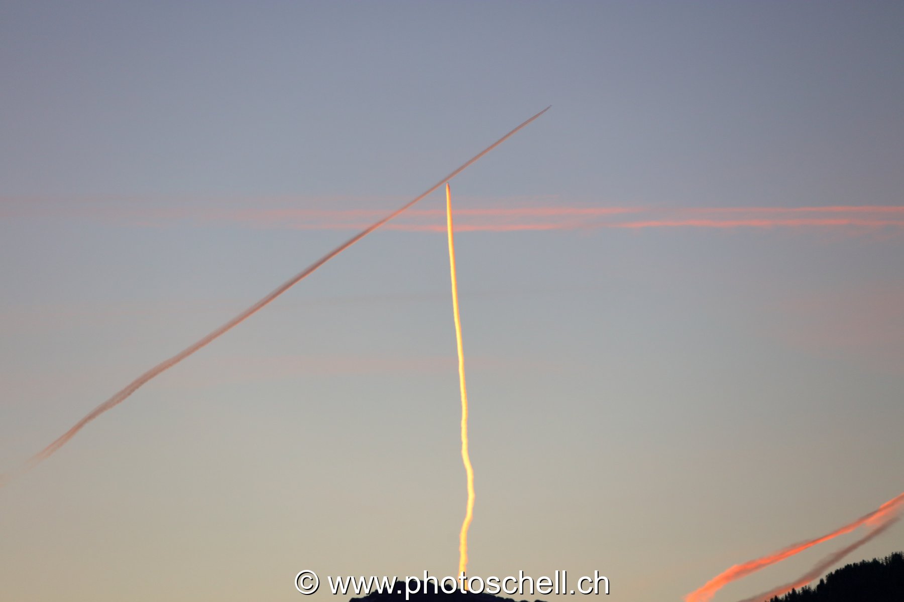 Trainées de condensation d'avions avant le lever de soleil
