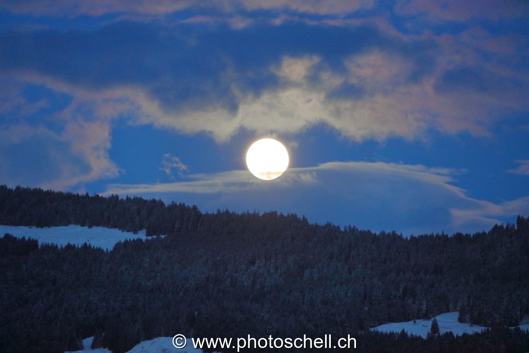 Lever de pleine lune dans les nuages
