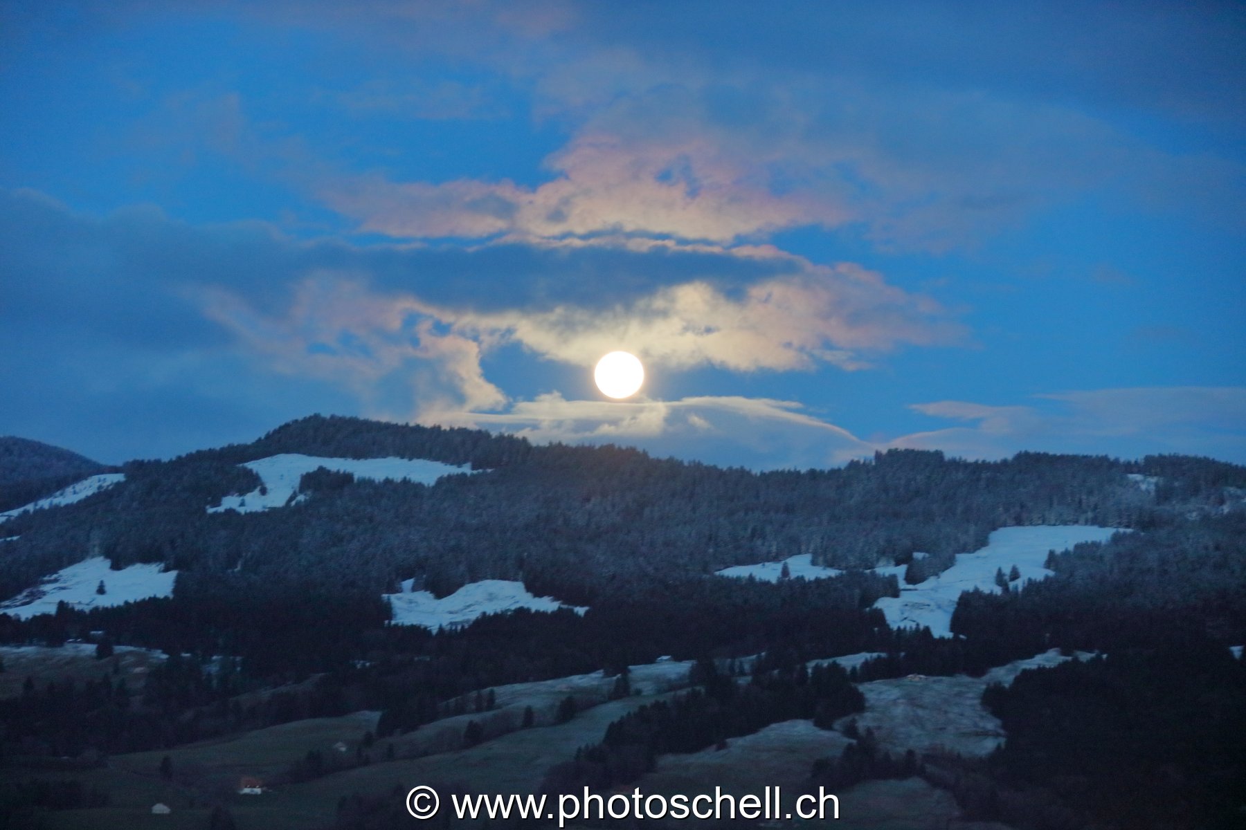 Lever de pleine lune dans les nuages