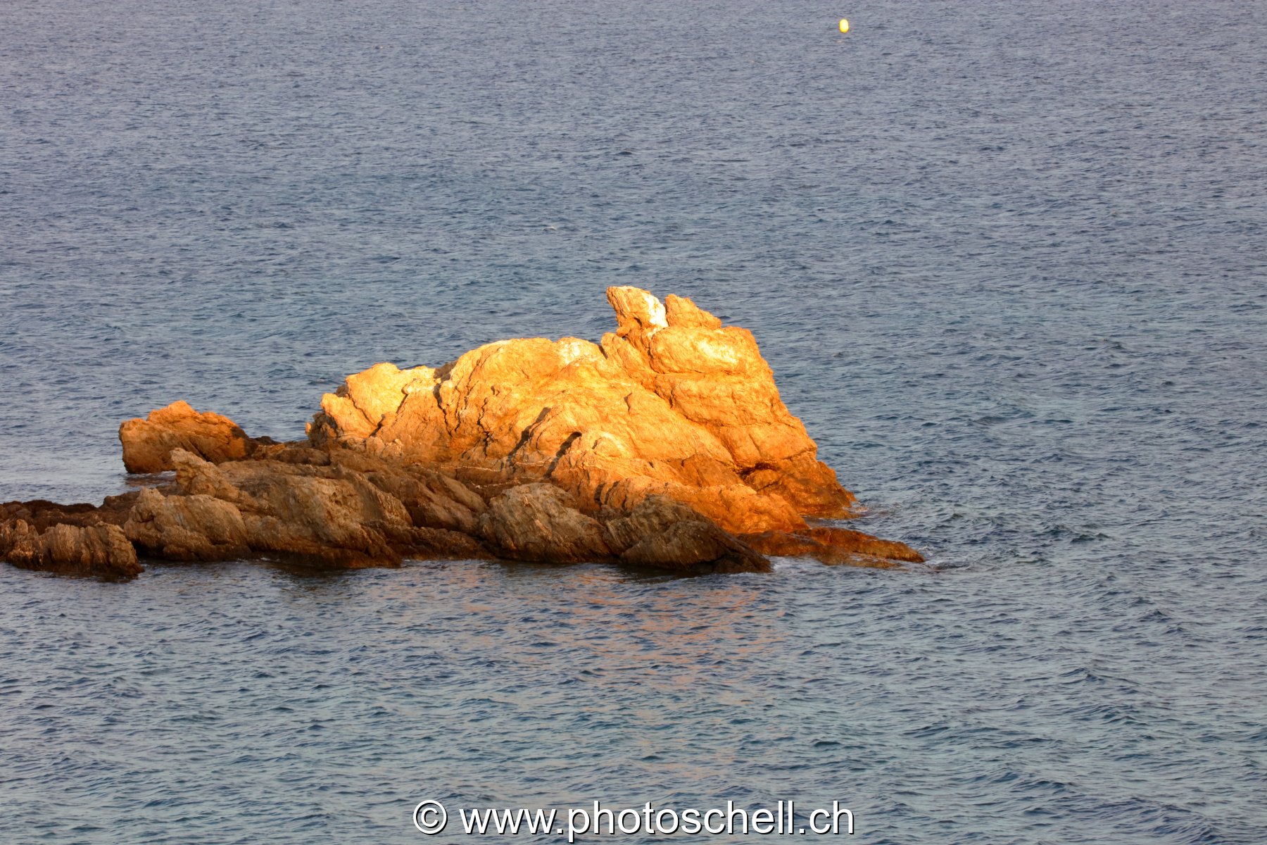 Coucher de soleil sur un rocher en mer