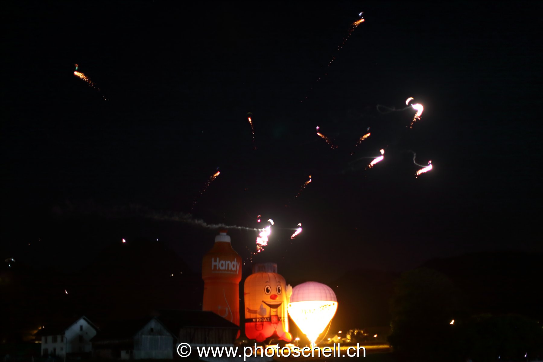 Mongolfières la nuit et parapentes illuminés