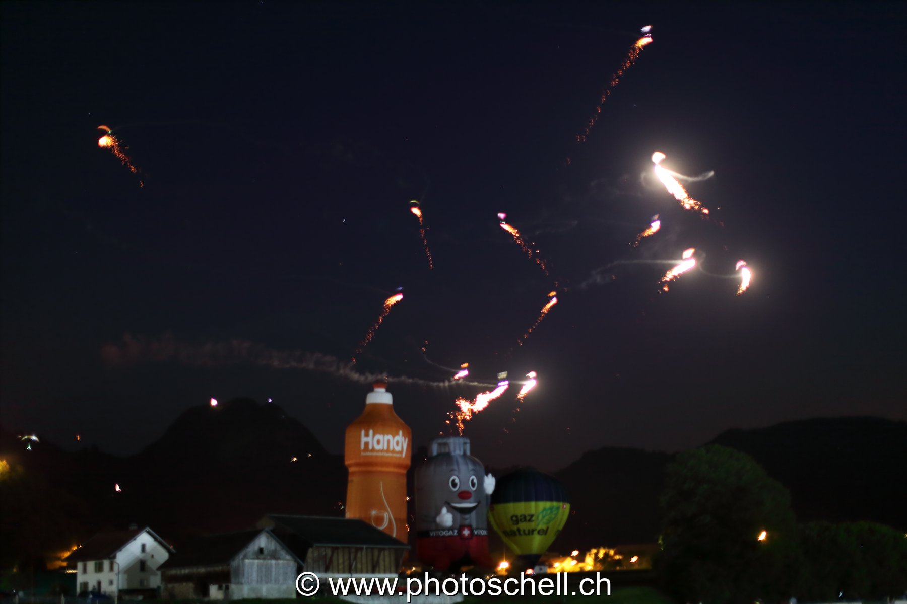 Mongolfières la nuit et parapentes illuminés