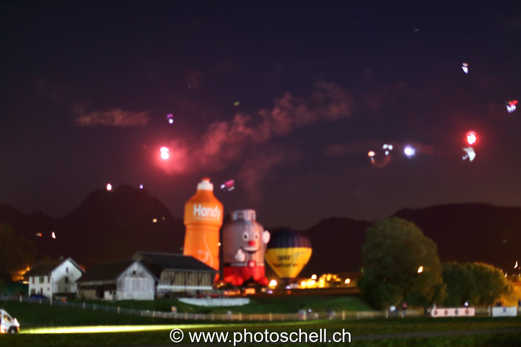Mongolfières la nuit et parapentes illuminés