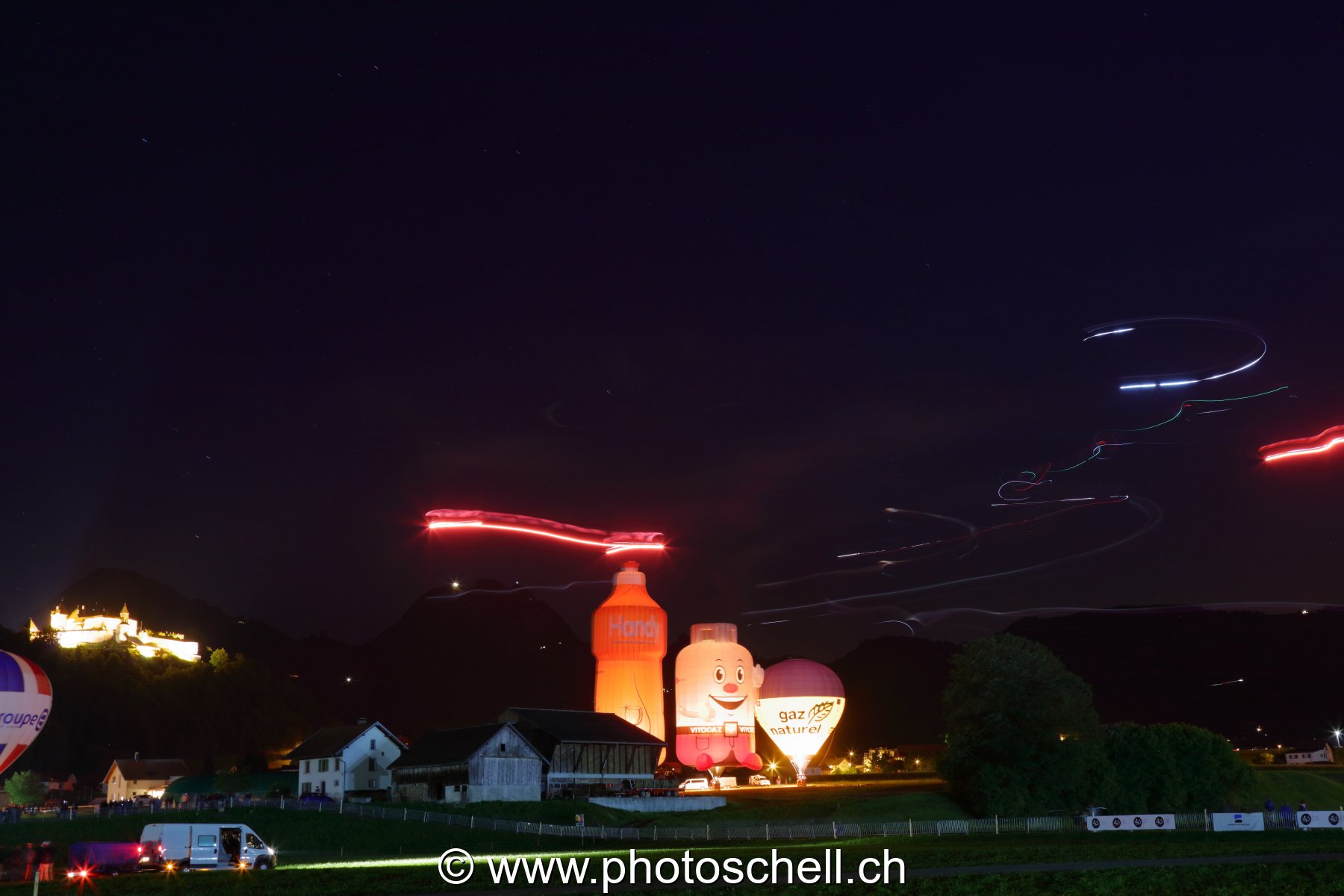 Mongolfières la nuit et parapentes illuminés