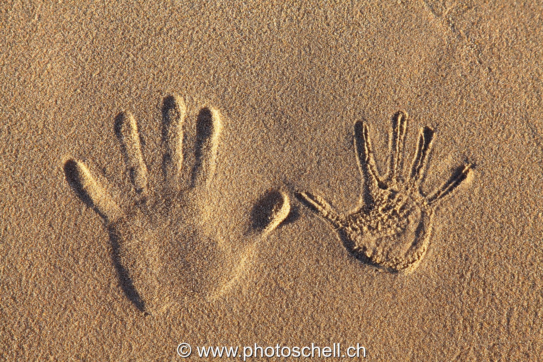 Empreintes de mains dans le sable