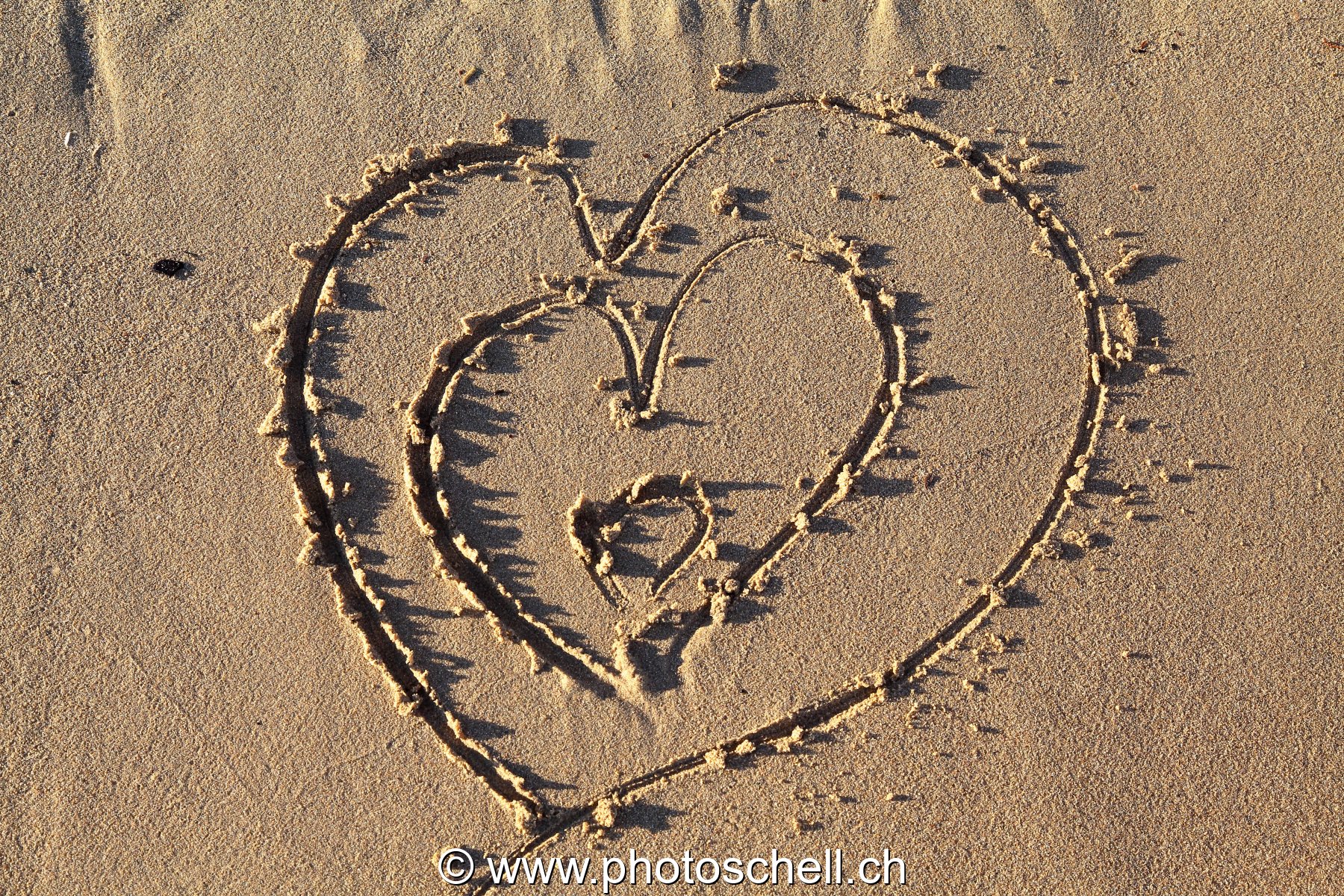 Coeurs griffés dans le sable