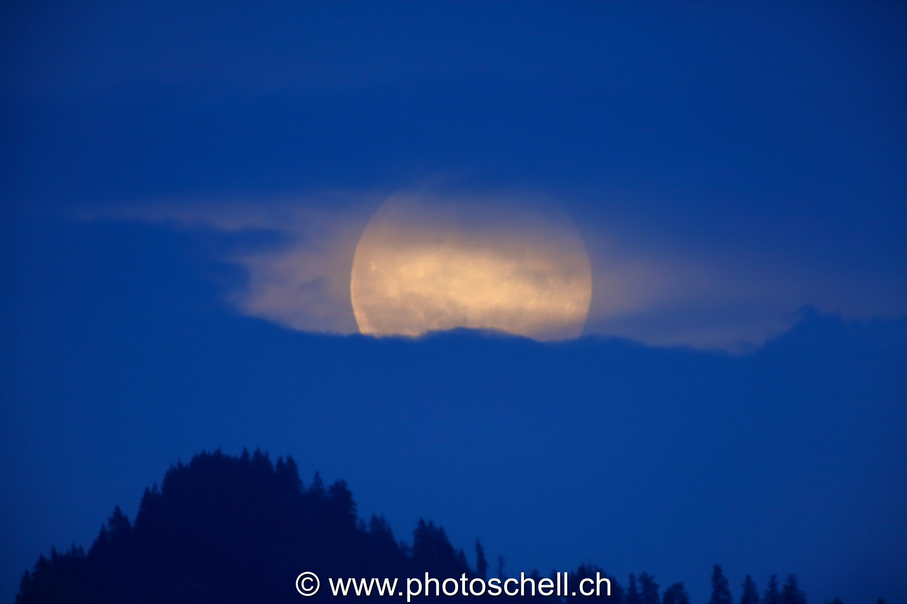 Lever de pleine lune dans les nuages