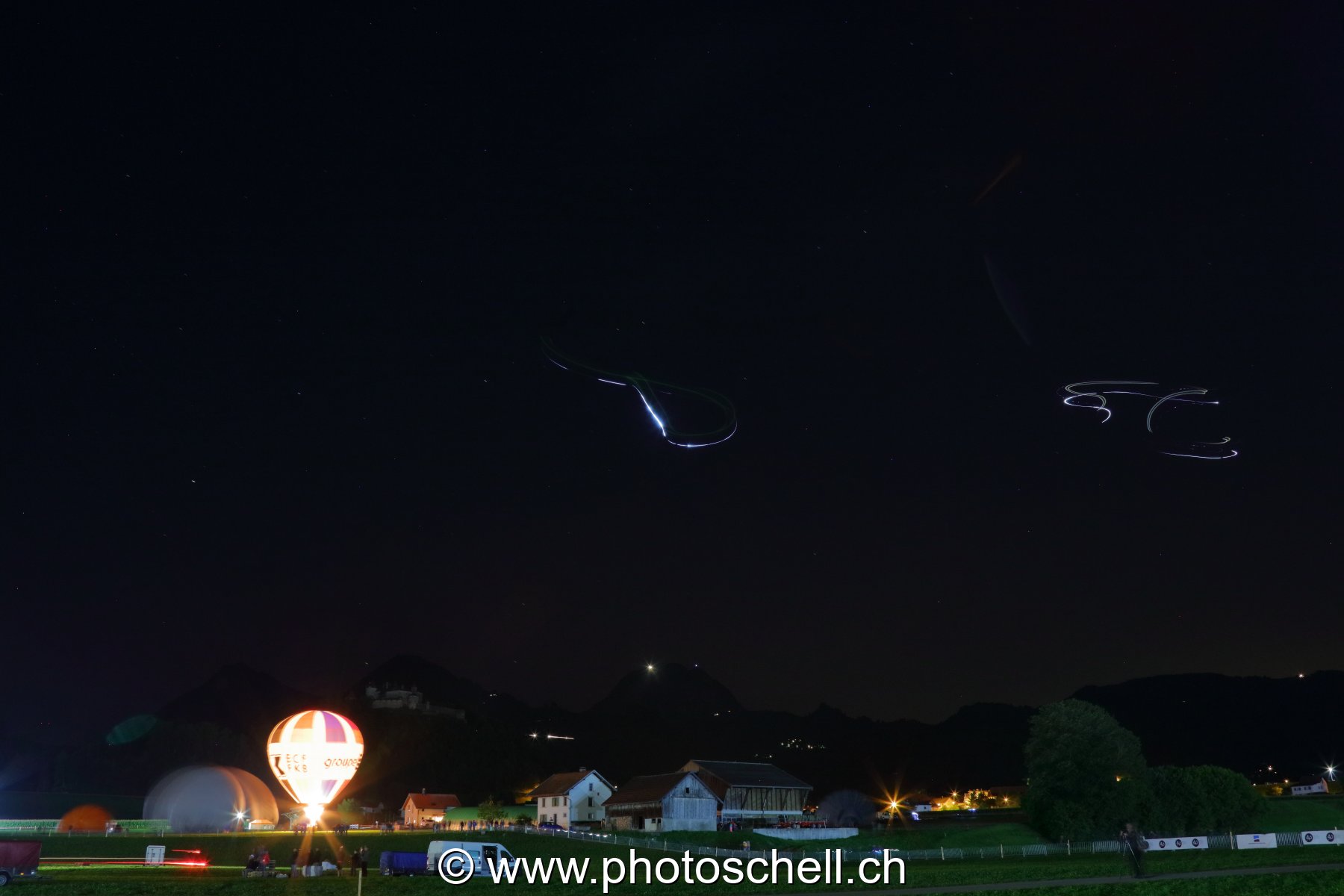 Trainées de lumières dues à des parapentistes la nuit