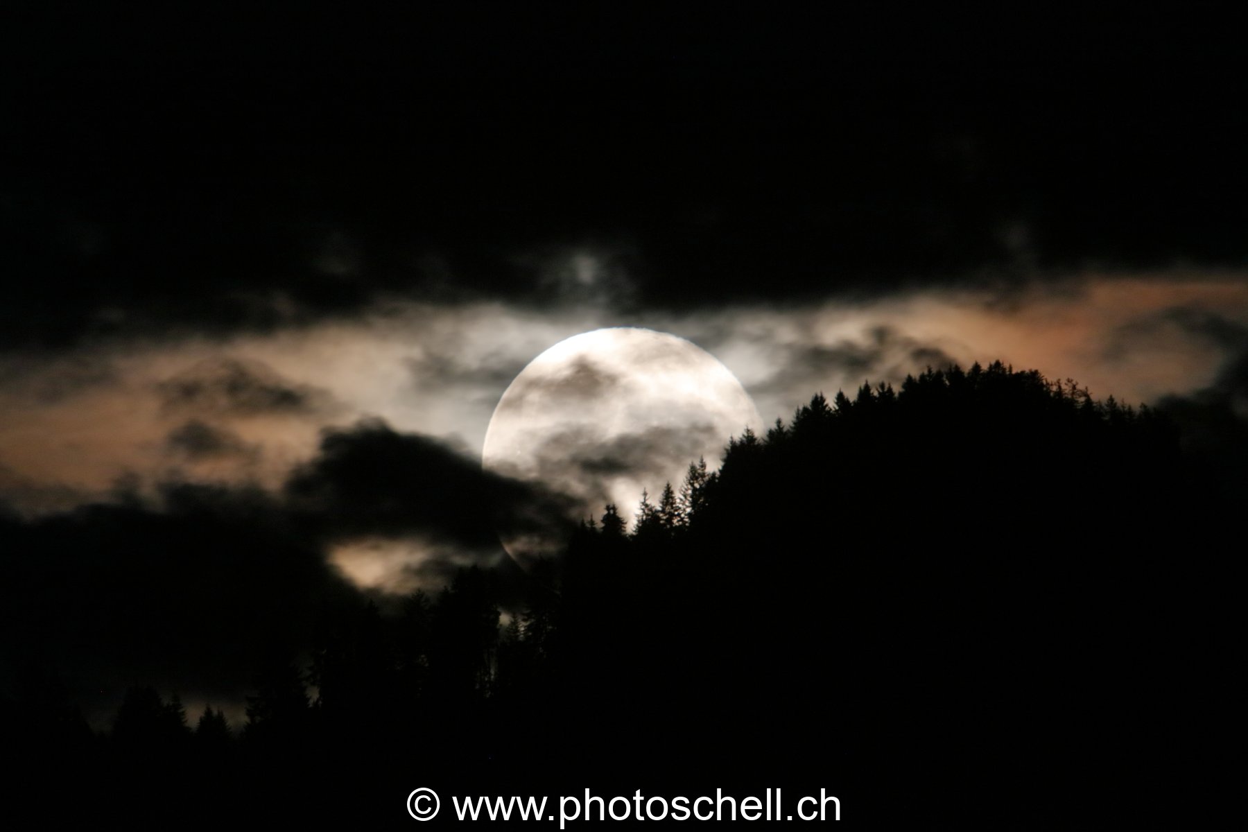 Lever de pleine lune dans les nuages