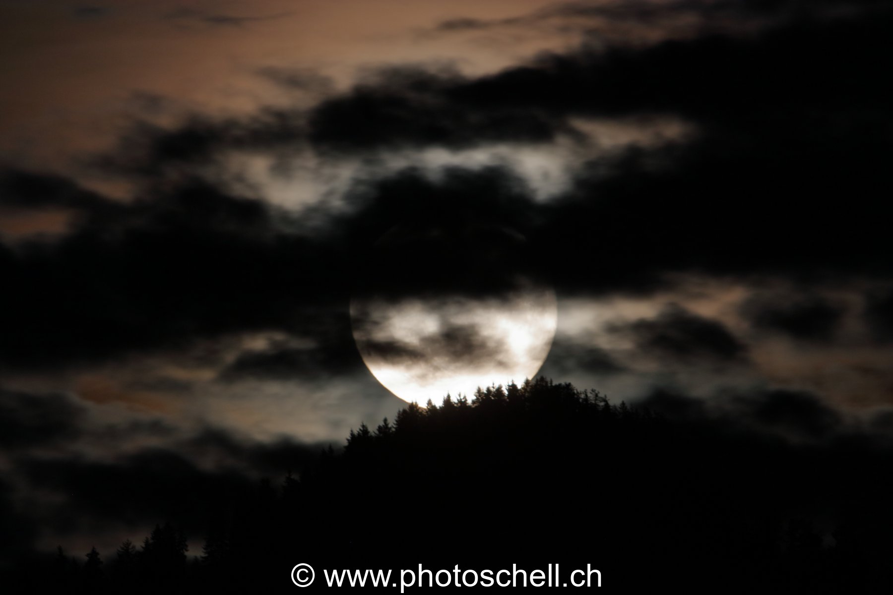 Lever de pleine lune dans les nuages